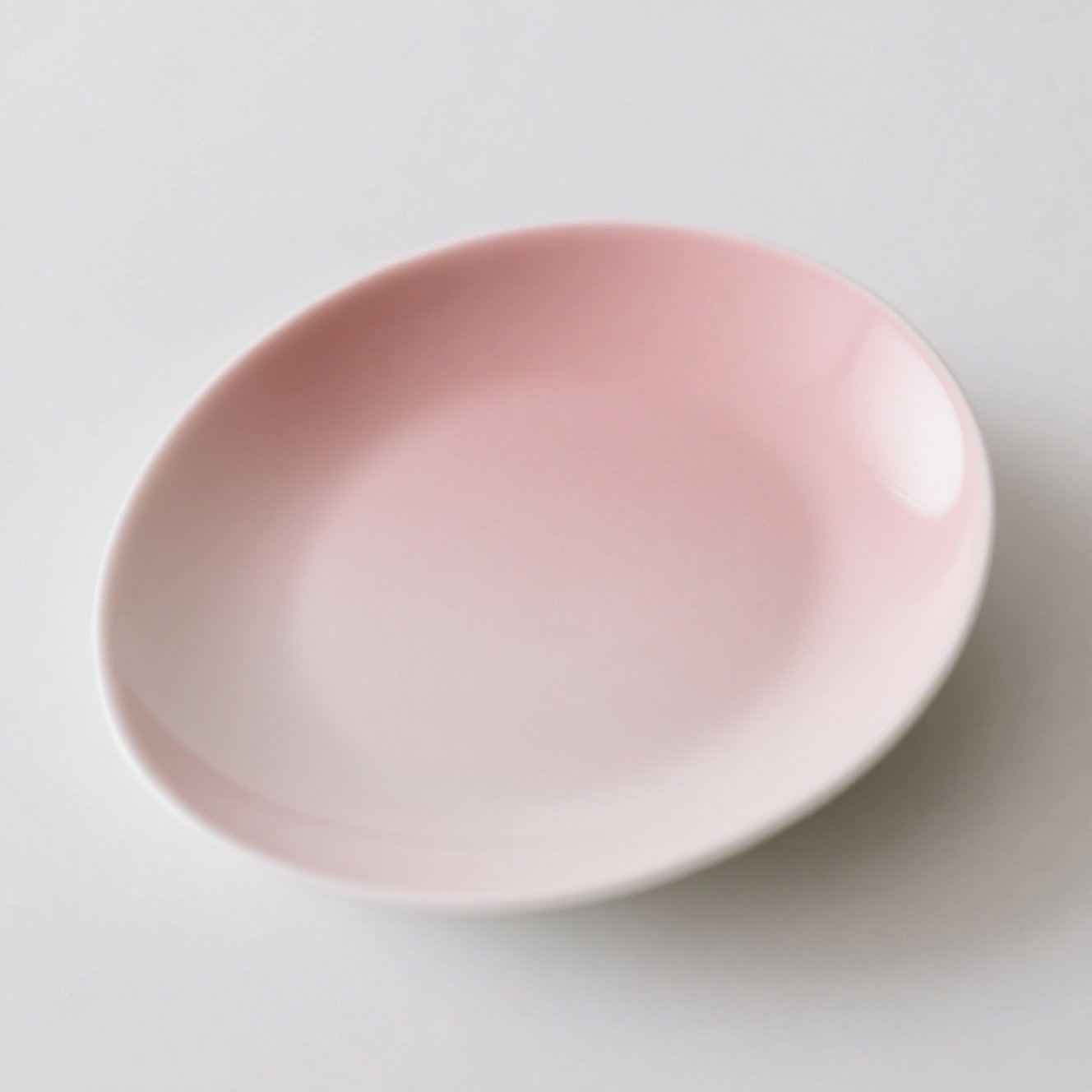 Porcelánový talíř v růžové barvě na stole