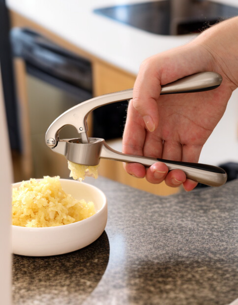 Machacador de ajos multifuncional en uso en la cocina