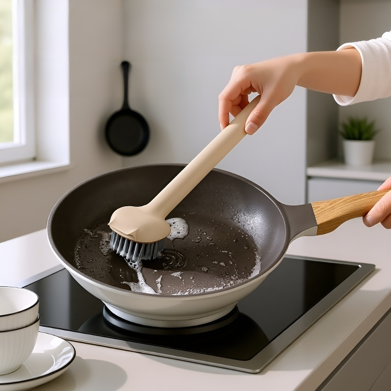 냄비 세척 솔을 사용하는 손