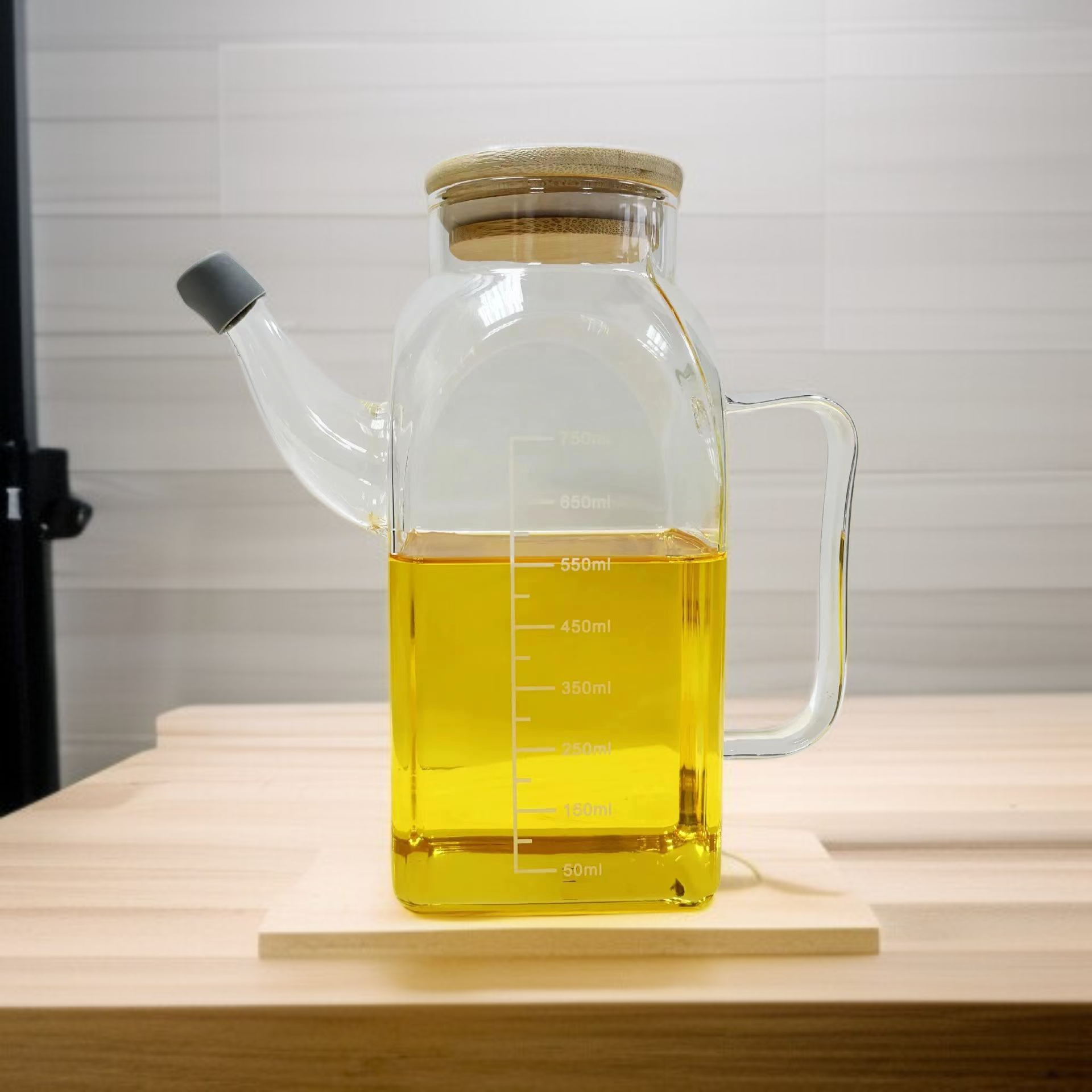 Ölflasche aus Glas mit Ausgießer auf Küchentisch