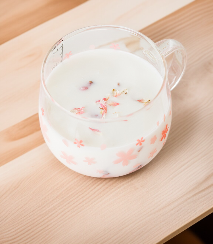 Transparentes Glas mit rosa Kirschblüten für Getränke