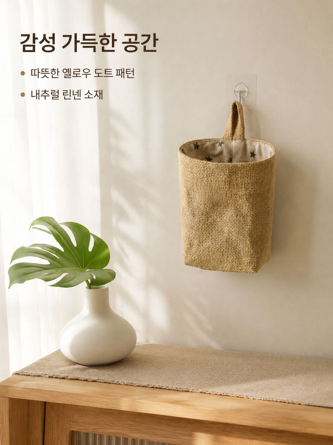 노란색 면과 린넨 소재의 벽걸이형 수납 가방이 문 뒤에 걸려 있습니다.