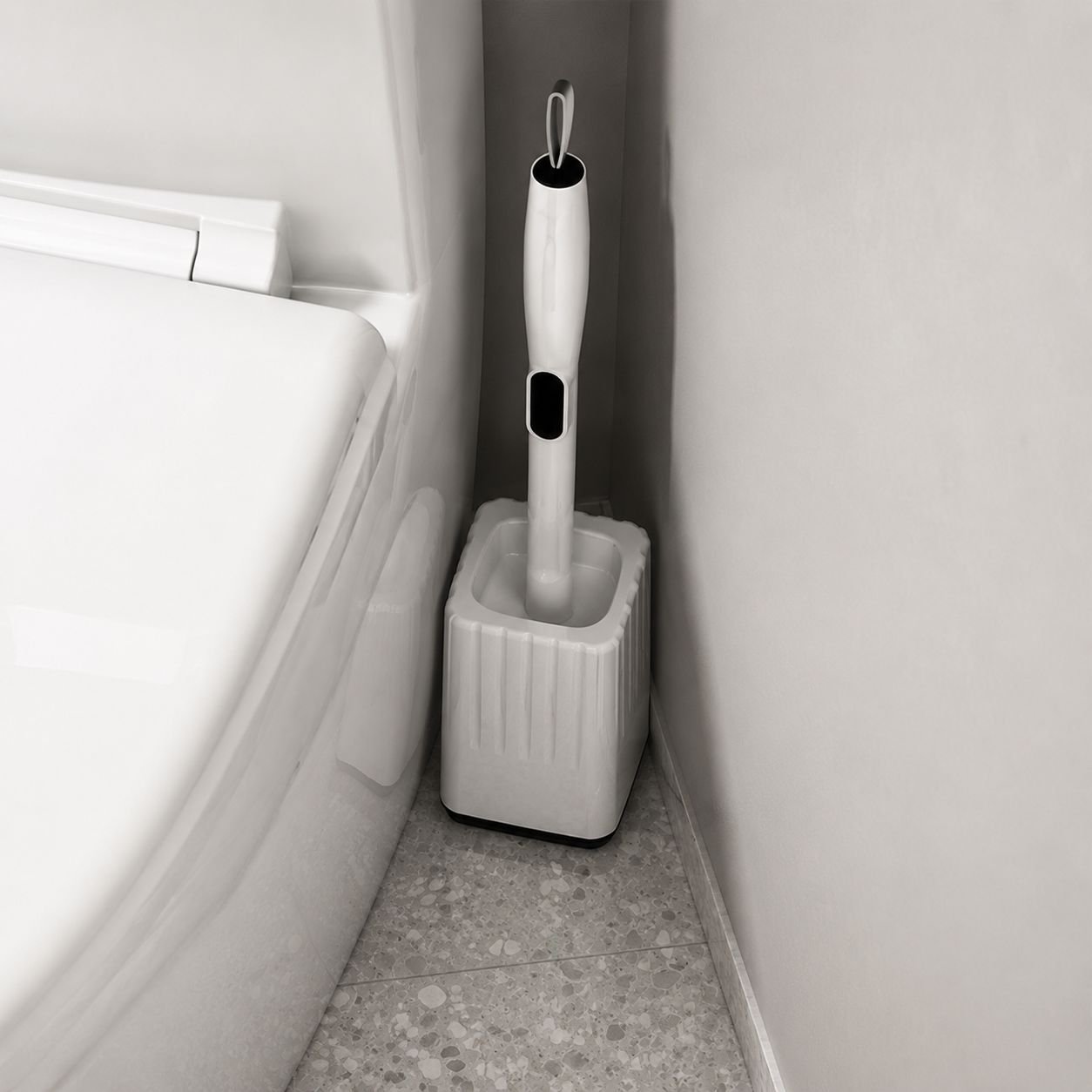 Corner cleaning brush reaching behind toilet in bathroom