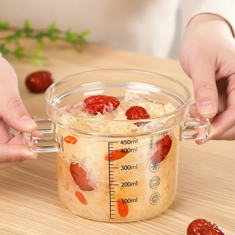 Kleiner Glas-Kochtopf beim Servieren von Suppe